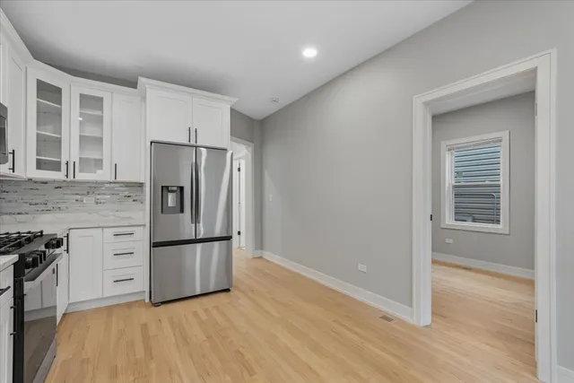 a kitchen with granite countertop a refrigerator and a stove top oven