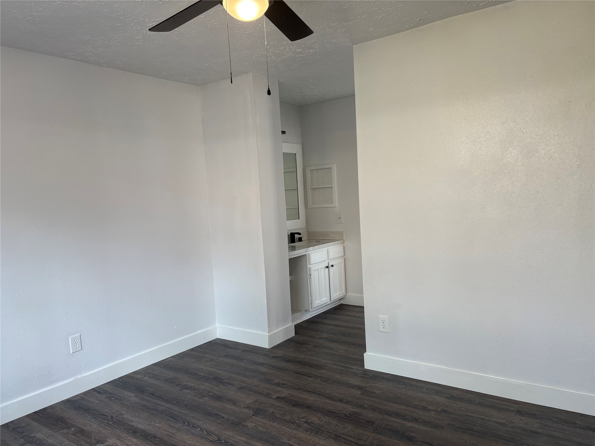 4631 Enchanted Rock Lane Spring, TX 77388 - Photo 2 of 10 Unfurnished room with dark wood-style flooring, a textured ceiling, and a ceiling fan