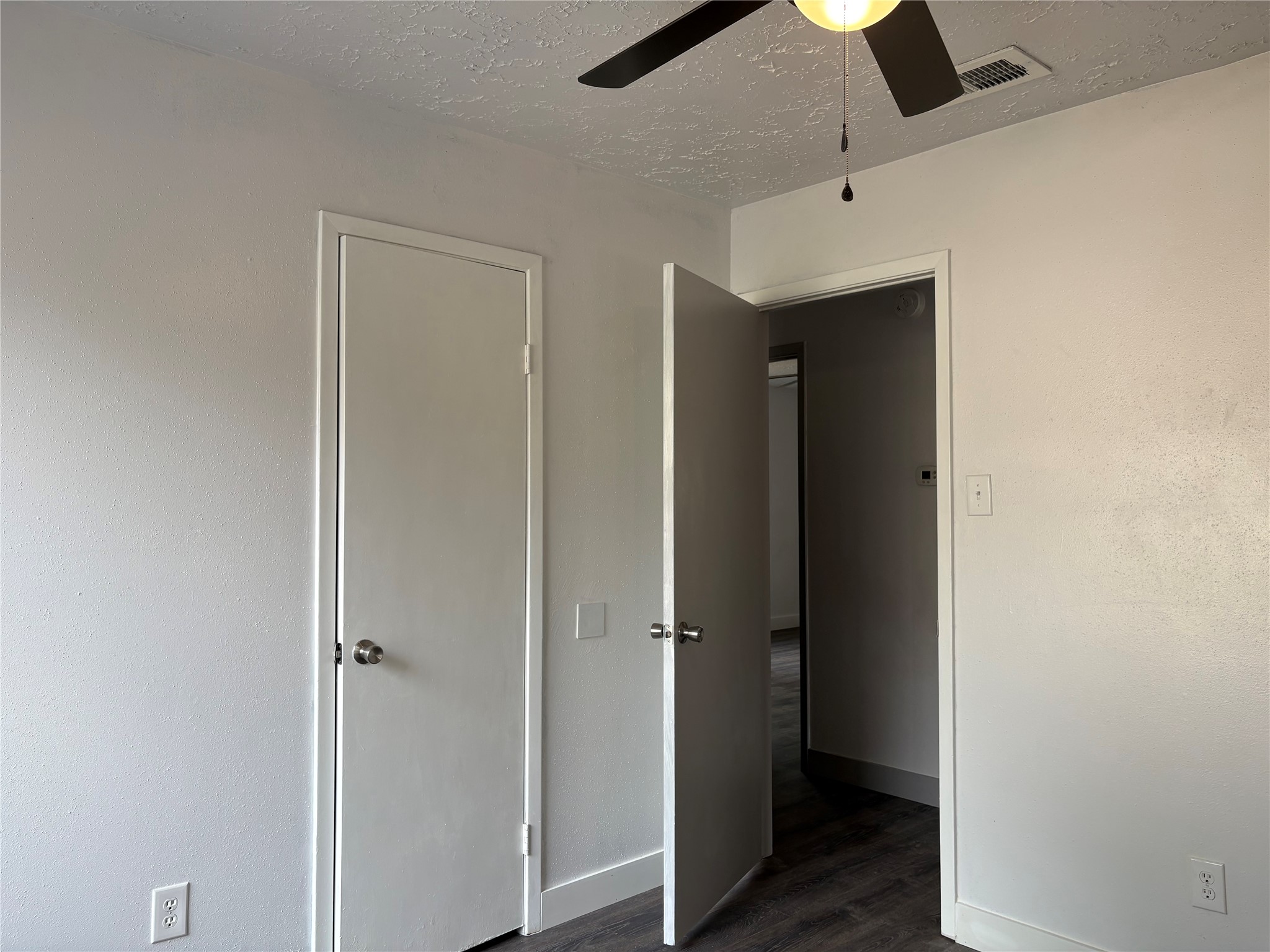 4631 Enchanted Rock Lane Spring, TX 77388 - Photo 8 of 10 Unfurnished bedroom featuring dark wood-type flooring, ceiling fan, and a textured ceiling