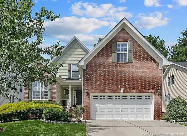 a front view of house with a yard and trees