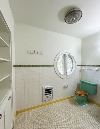 a bathroom with a toilet a sink and a mirror