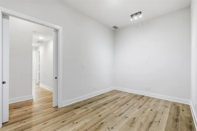 an empty room with wooden floor and fireplace