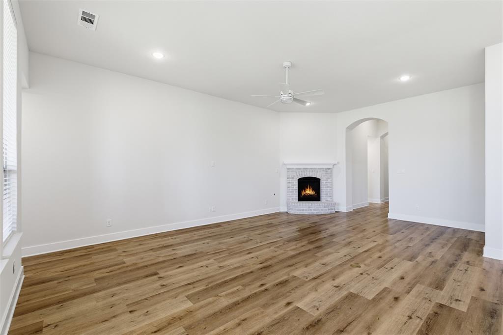 4400 Rocky Rdg Trail Little Elm, TX 75068 - Photo 14 of 40 an empty room with wooden floor and fireplace