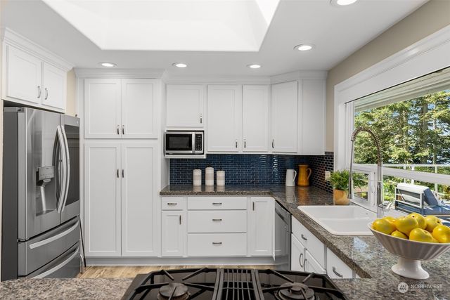 a kitchen with stainless steel appliances granite countertop a stove and a sink