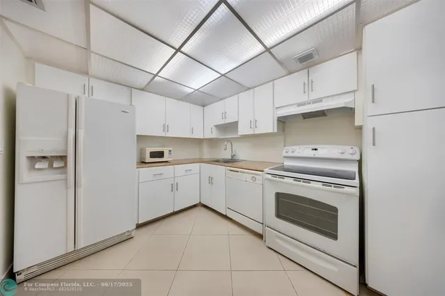 a kitchen with white cabinets and white appliances