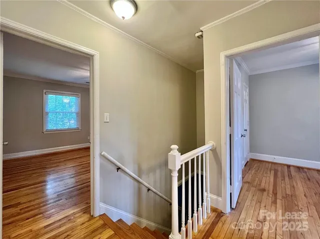 a view of a hallway with wooden floor and staircase