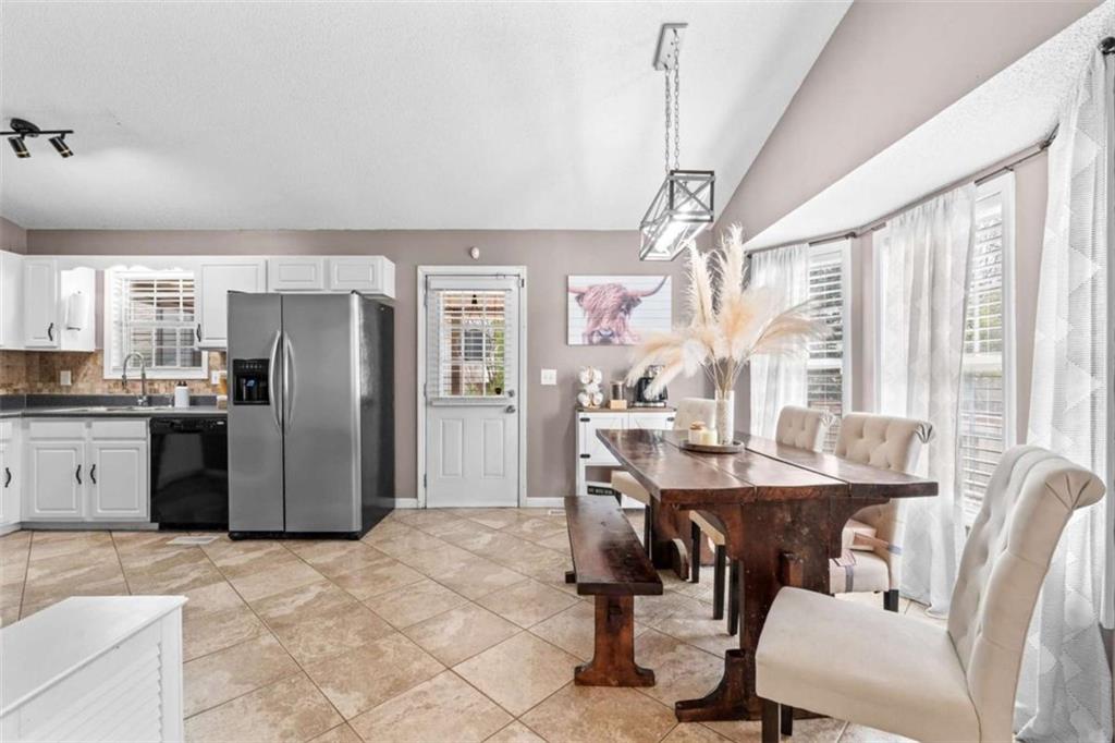 105 Chrissy Drive Temple, GA 30179 - Photo 13 of 47 a kitchen with stainless steel appliances kitchen island granite countertop a table chairs and a refrigerator