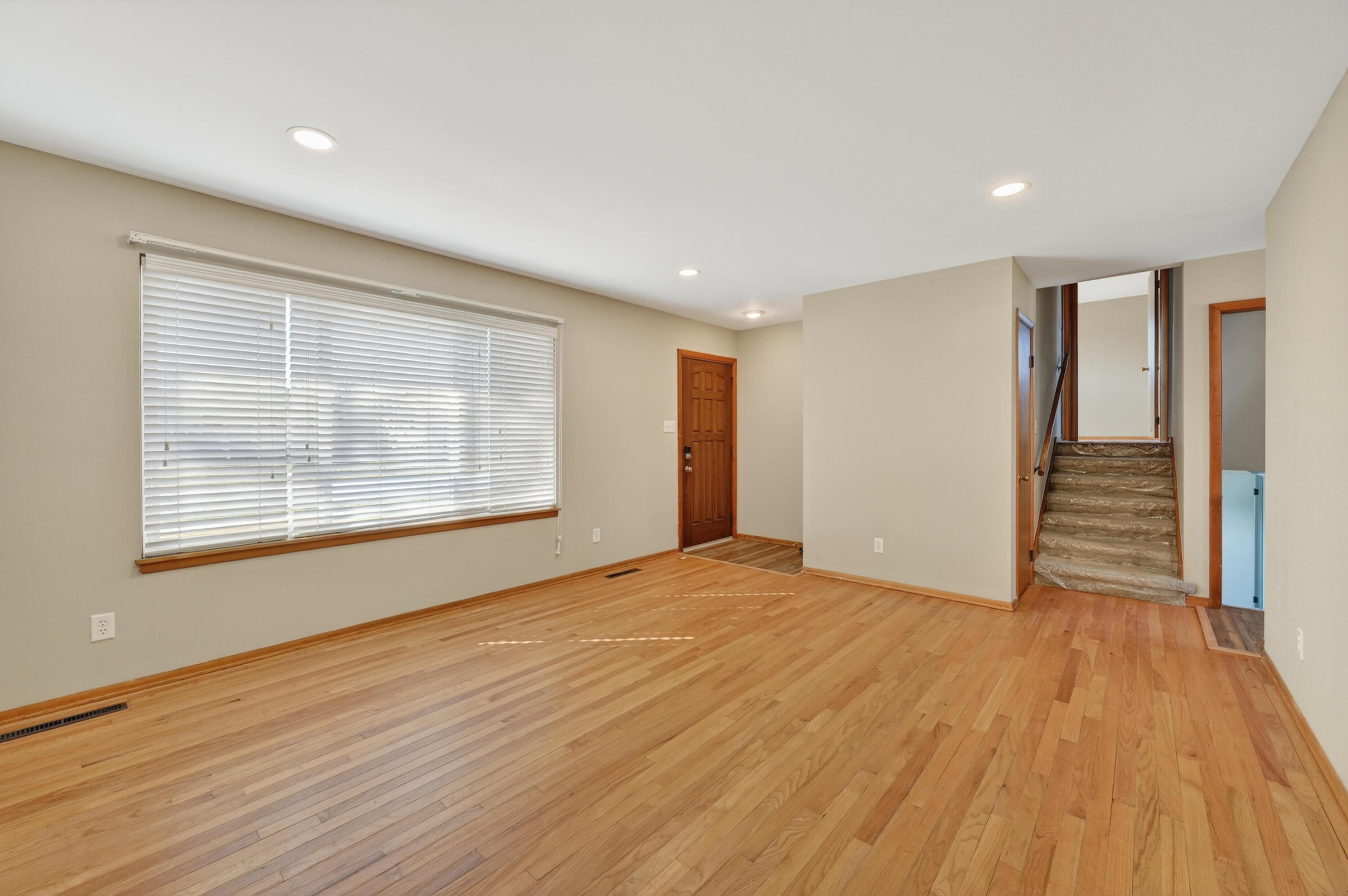 1006 West Ash Street Griffith, IN 46319 - Photo 7 of 25 a view of an empty room with wooden floor and a window