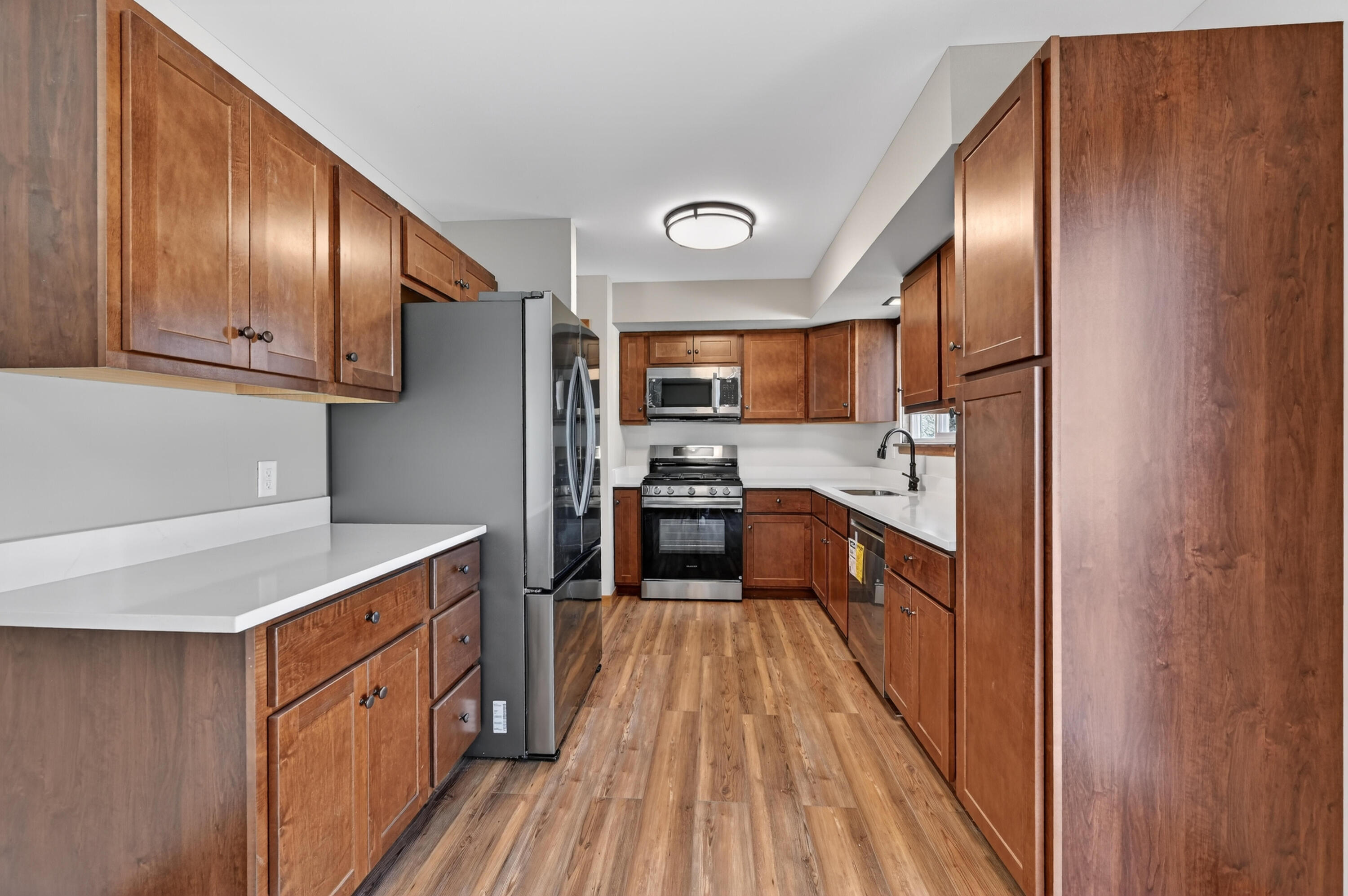 1006 West Ash Street Griffith, IN 46319 - Photo 10 of 25 a kitchen with stainless steel appliances granite countertop a refrigerator a stove top oven with wooden floor