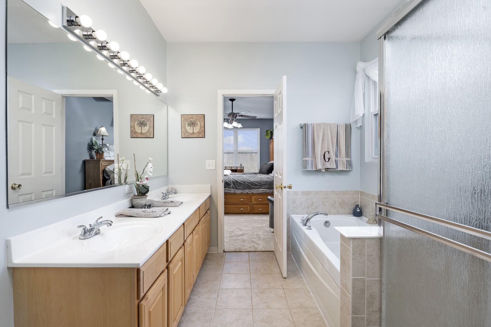25420 Spring Street Manhattan, IL 60442 - Photo 16 of 27 a bathroom with a double vanity sink a mirror and a bathtub
