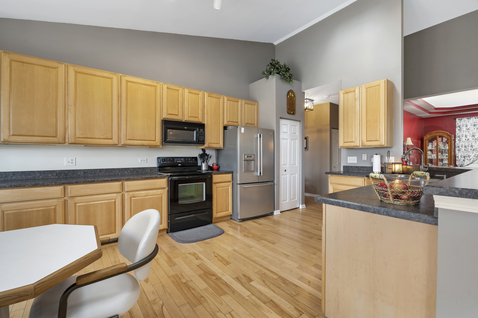 25420 Spring Street Manhattan, IL 60442 - Photo 21 of 27 a kitchen with granite countertop wooden cabinets a stove top oven a sink and dishwasher