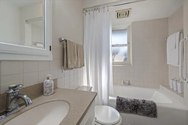 a bathroom with a granite countertop sink toilet and shower