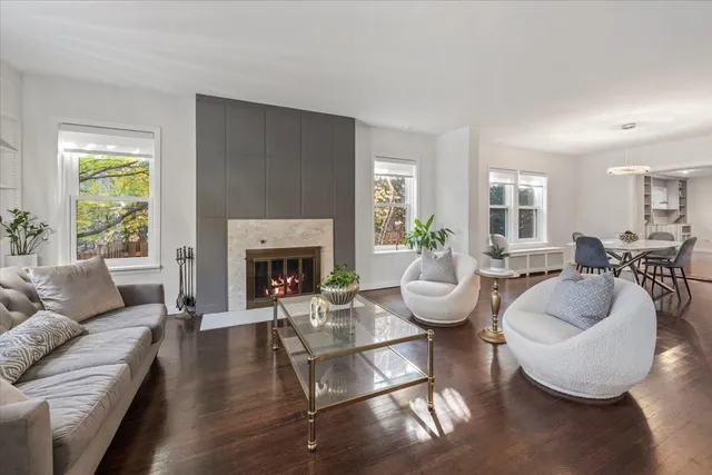 a living room with furniture a fireplace and a large window