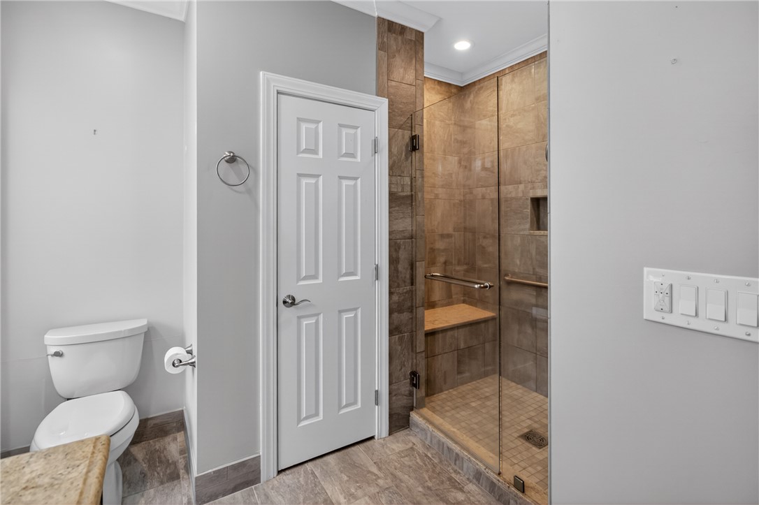 106 Newington Circle Anderson, SC 29621 - Photo 18 of 27 This bathroom features a sleek glass-enclosed shower with tile flooring and an elegant toilet area.