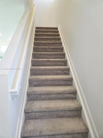 a view of a hallway with wooden floor and closet