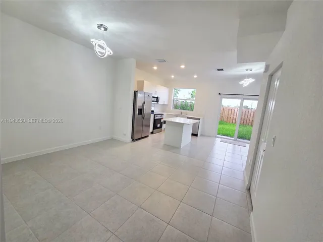 a kitchen with stainless steel appliances granite countertop a sink and a refrigerator
