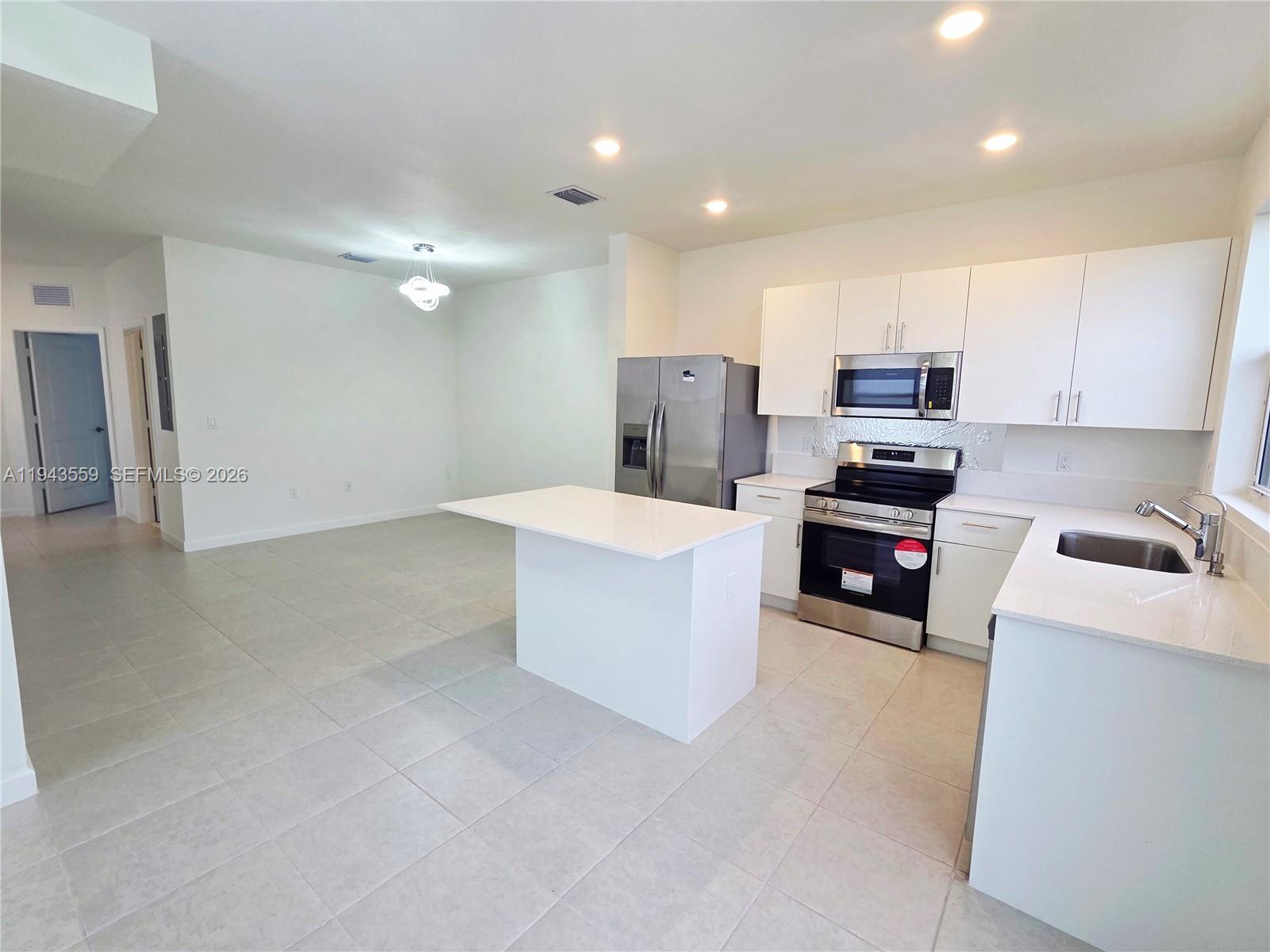 17925 Southwest 358th Street Homestead, FL 33034 - Photo 6 of 25 a kitchen with kitchen island cabinets and appliances