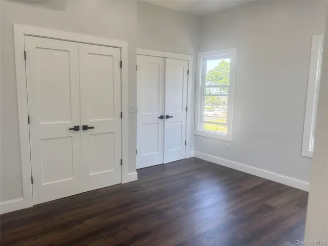 an empty room with wooden floor and a window