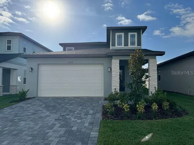 a front view of a house with a garden and garage