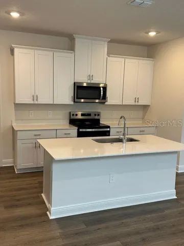 a kitchen with stainless steel appliances granite countertop a sink a stove and a microwave