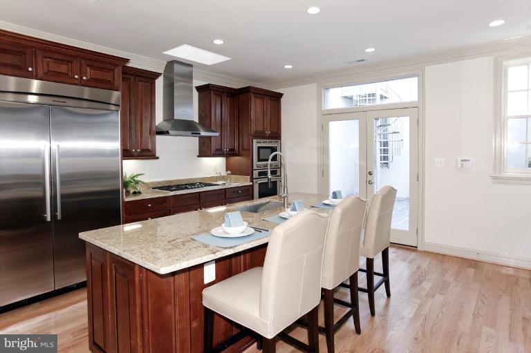 18 7th Street Northeast Washington, DC 20002 - Photo 19 of 27 a kitchen with granite countertop a table chairs microwave and refrigerator