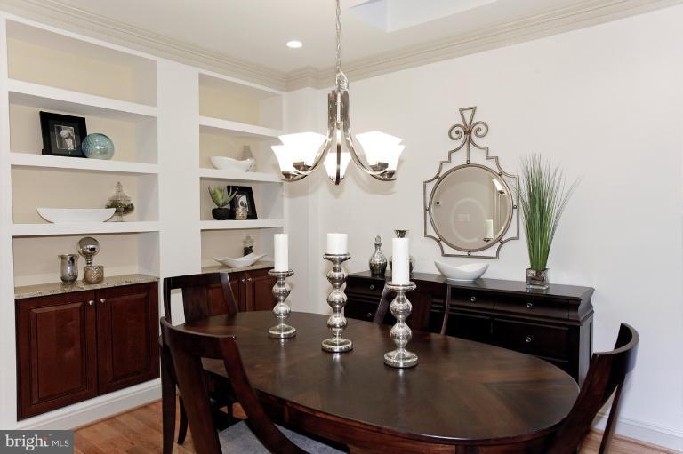 18 7th Street Northeast Washington, DC 20002 - Photo 24 of 27 a dining room with wooden floor a chandelier a wooden table and chairs