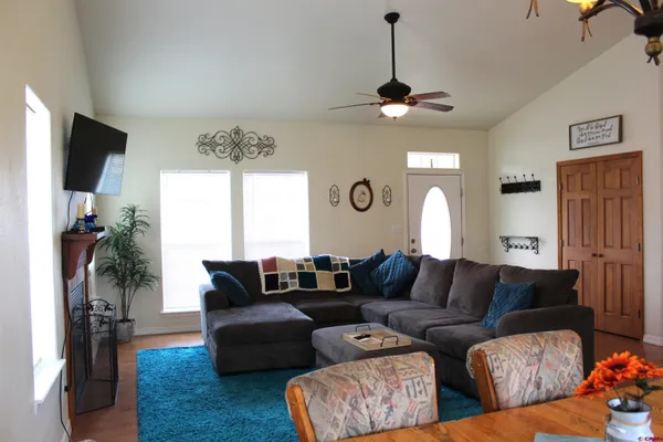 a living room with furniture a flat screen tv and a window