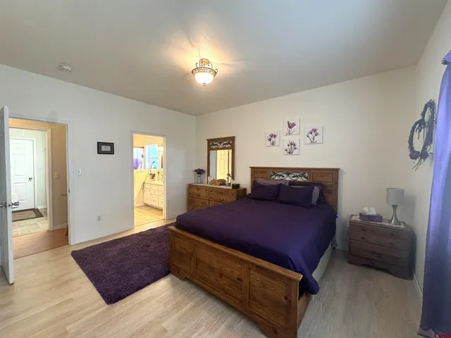 a bedroom with a bed and a lamp on dresser