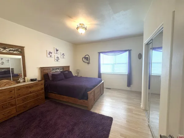 a spacious bedroom with a bed and a view of bedroom