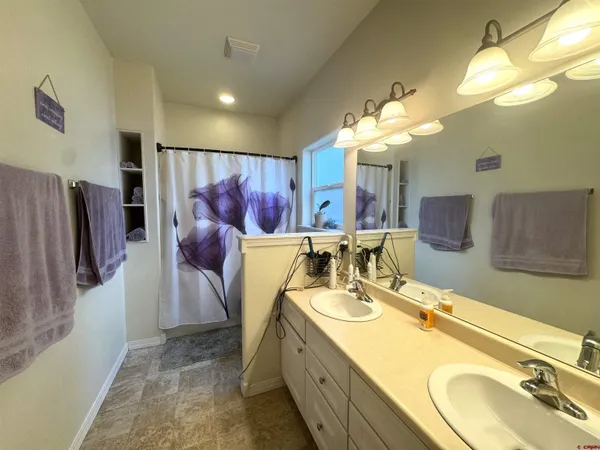 a bathroom with a double vanity sink mirror and shower