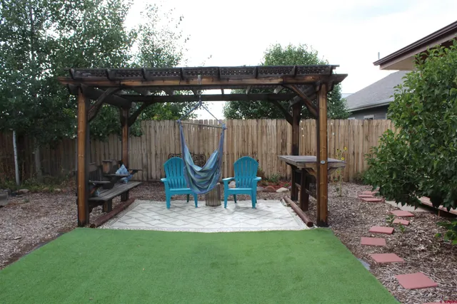 a view of table and chairs in patio with wooden fence