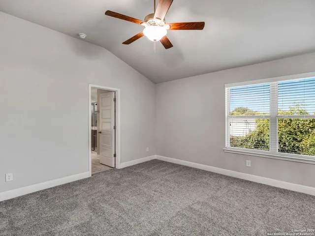 an empty room with windows and fan