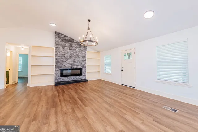 a view of empty room with wooden floor and fireplace