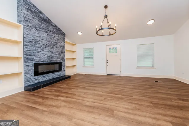 a view of empty room with wooden floor and fireplace