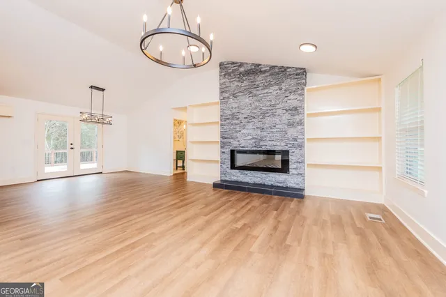 a view of empty room with wooden floor and fireplace