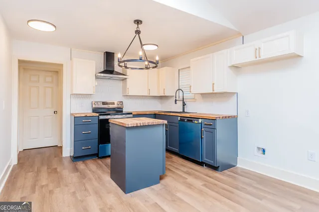 a kitchen with stainless steel appliances granite countertop a sink dishwasher a stove and a microwave oven with cabinets