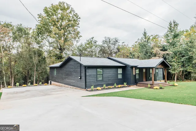 a front view of a house with a yard and trees