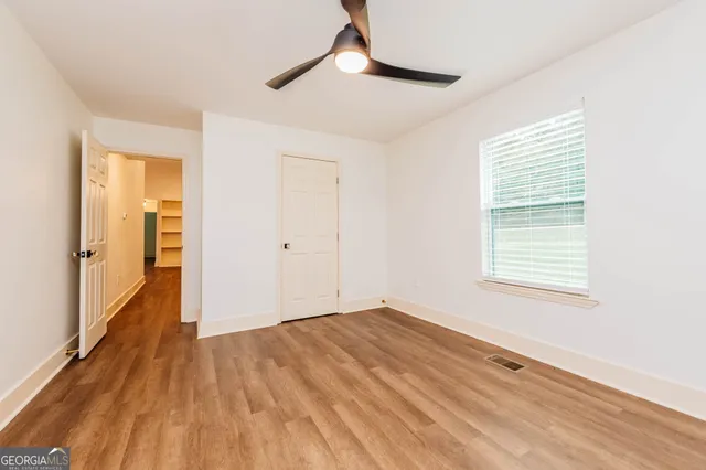 a view of a big room with wooden floor and windows in a room