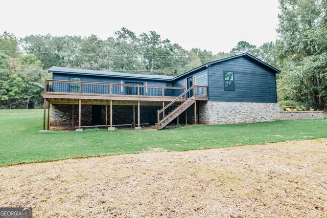 a front view of house with yard and trees in the background