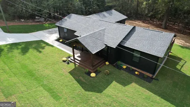a front view of a house with a yard and trees
