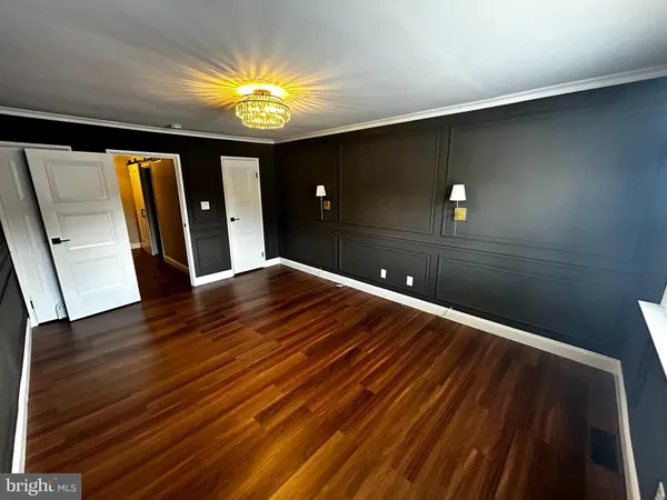 a view of empty room with window and wooden floor