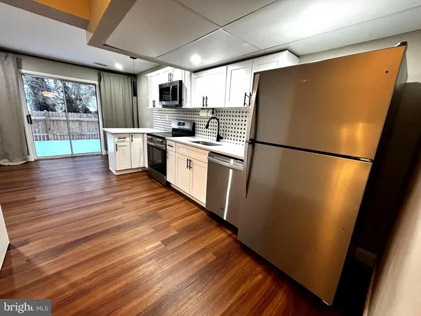 a kitchen with refrigerator a microwave and cabinets