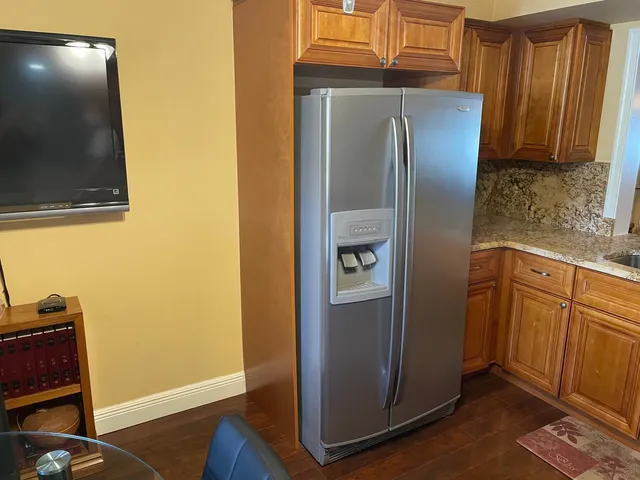 a view of a hallway with white walls and wooden floors