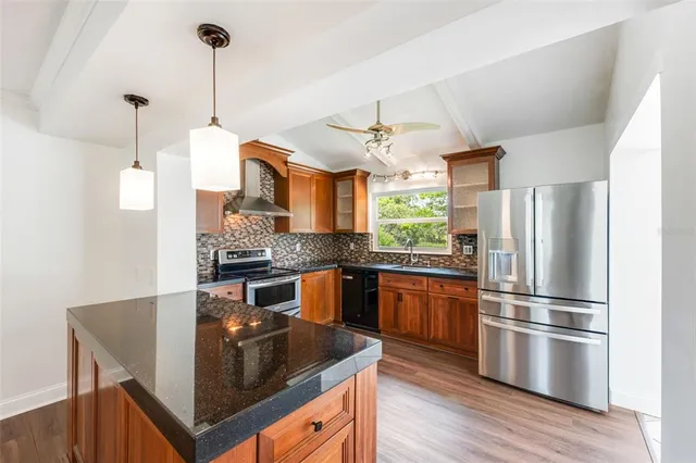 a kitchen with kitchen island a counter top space appliances and cabinets