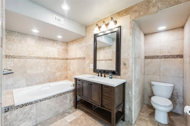 a spacious bathroom with a bathtub sink and toilet