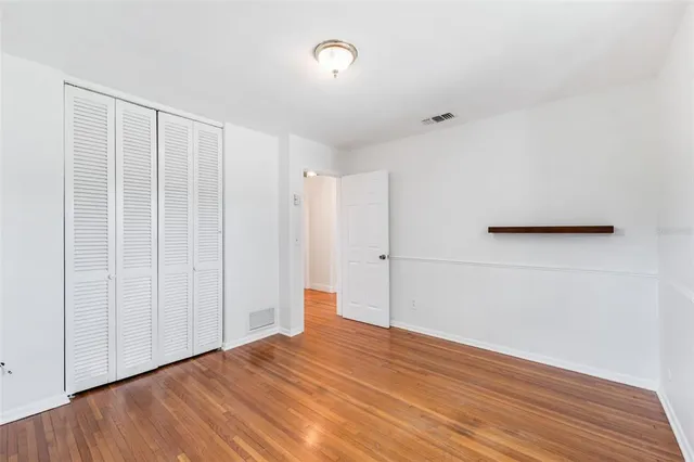 a view of an empty room with wooden floor