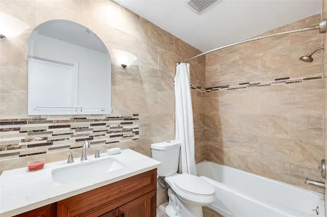 a bathroom with a sink toilet vanity and shower