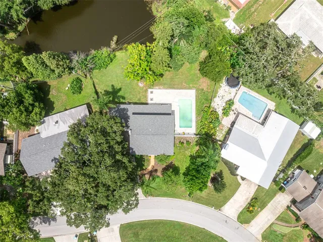 an aerial view of a house with a yard and lake view