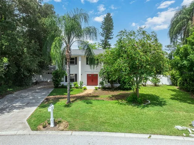 a view of a house with a yard and tree s