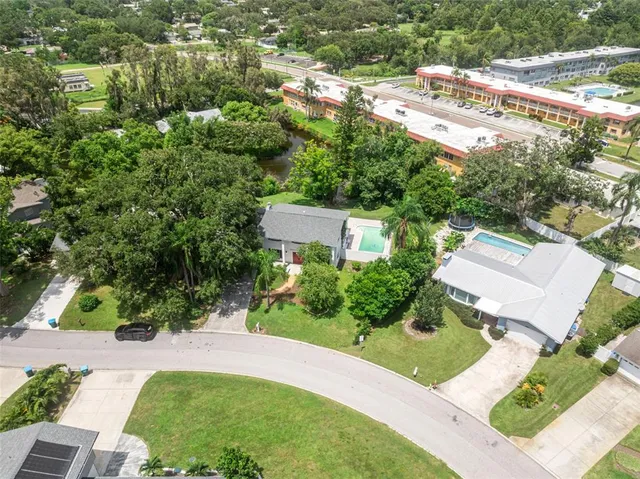an aerial view of a house with a yard and greenery